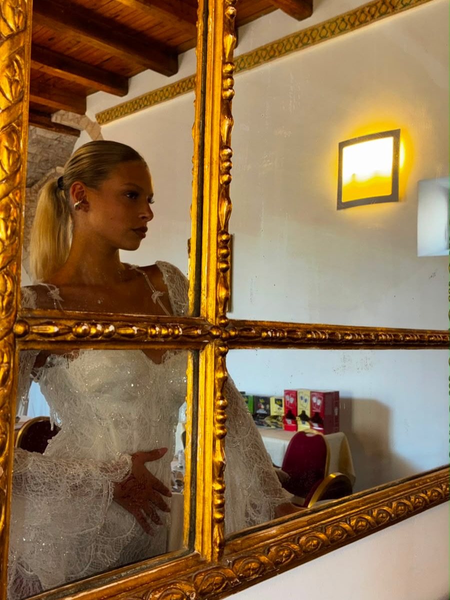 Volto di profilo riflesso in uno specchio dorato, abito da sposa in pizzo con maniche